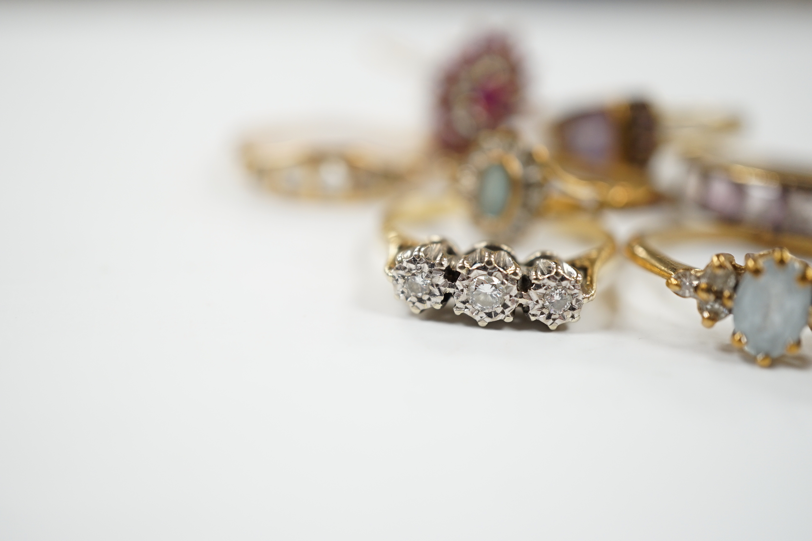 Seven assorted mainly modern 9ct gold and gem set dress rings, including three stone diamond and five stone diamond, gross weight 15.7 grams.
